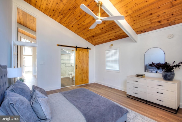 bedroom with light hardwood / wood-style flooring, vaulted ceiling, and a barn door