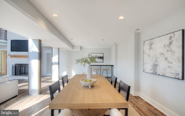 dining area featuring a fireplace and light hardwood / wood-style floors