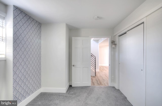 hallway featuring light colored carpet