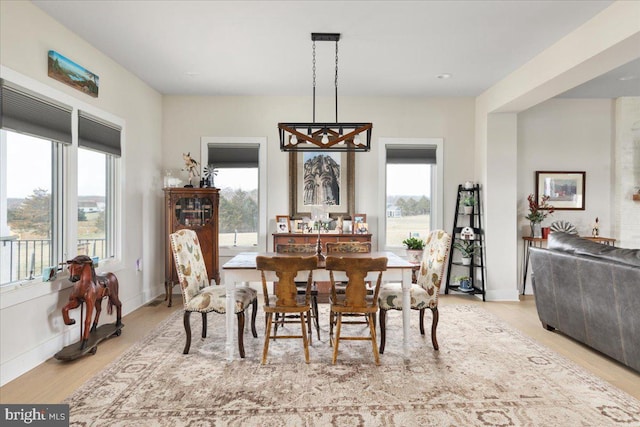 dining space featuring light wood-type flooring and baseboards