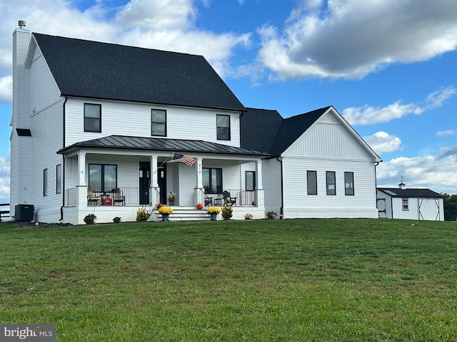 modern farmhouse style home featuring metal roof, a porch, a standing seam roof, and a front lawn