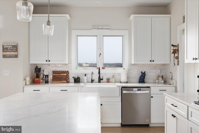 kitchen with a sink, tasteful backsplash, white cabinets, and stainless steel dishwasher