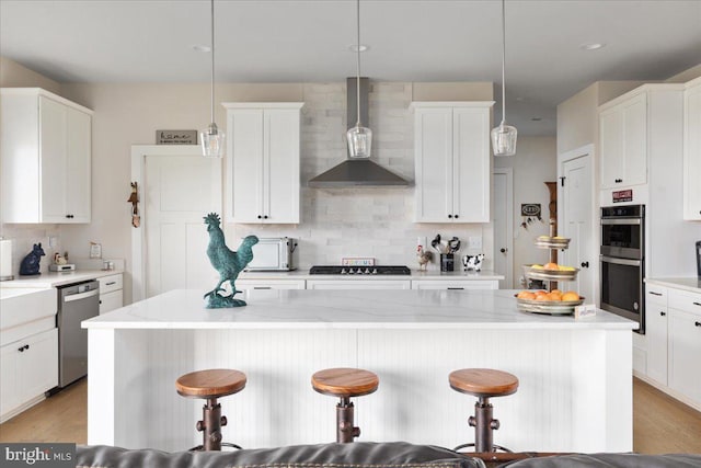 kitchen featuring a breakfast bar, wall chimney range hood, stainless steel appliances, and backsplash