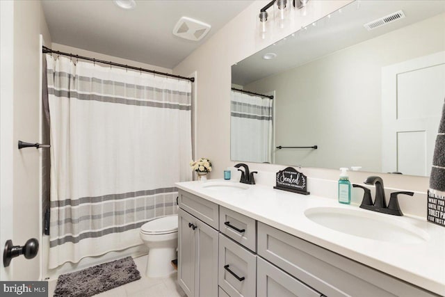 bathroom with toilet, a sink, and visible vents