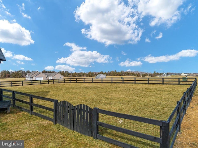 view of yard with fence and a rural view