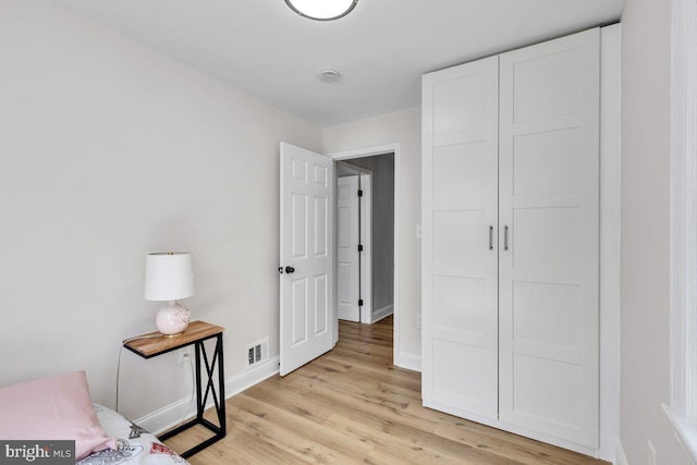 bedroom with a closet and light hardwood / wood-style flooring