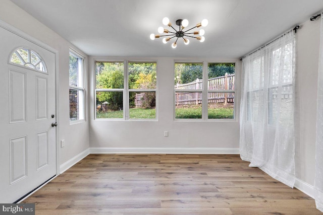 unfurnished sunroom featuring a notable chandelier