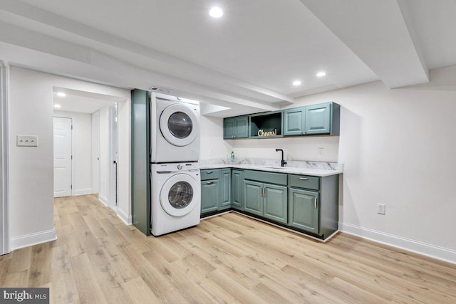 laundry area with stacked washer and dryer and light hardwood / wood-style floors