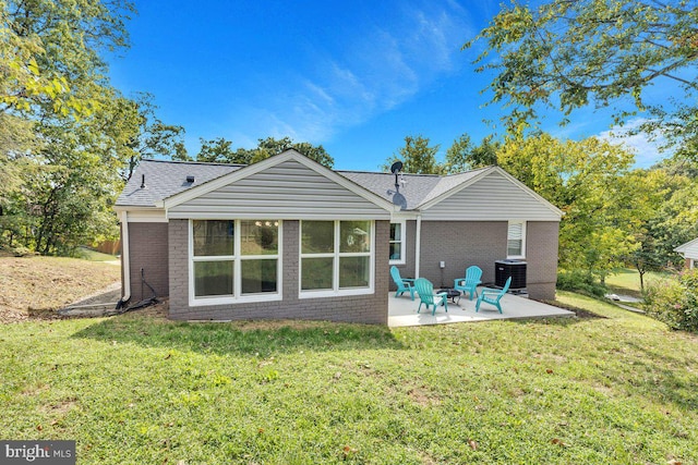 rear view of property featuring a yard, central AC unit, and a patio area