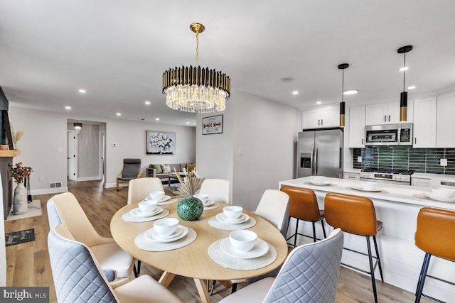 dining area featuring a notable chandelier and light hardwood / wood-style floors