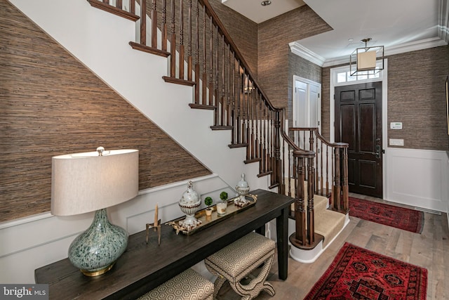 foyer entrance featuring ornamental molding and hardwood / wood-style floors