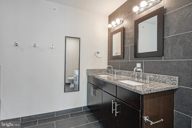 bathroom with tile walls, tile patterned flooring, backsplash, vanity, and toilet