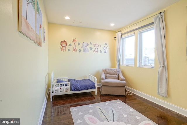 bedroom with dark hardwood / wood-style floors