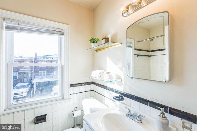 bathroom featuring sink, tile walls, and toilet