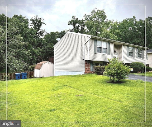 view of front of house with a storage unit and a front yard