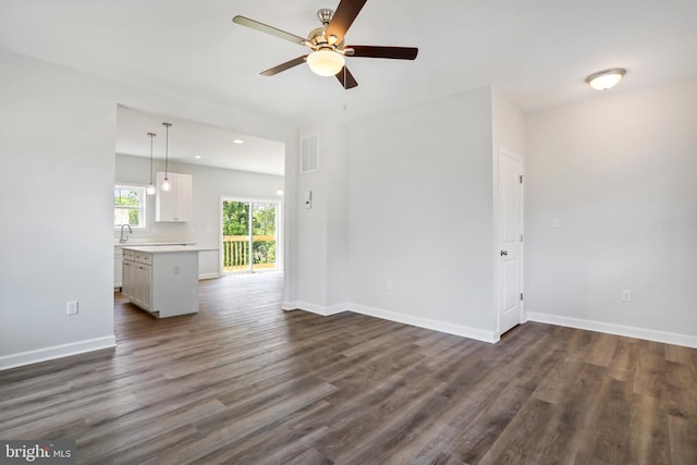 unfurnished living room with dark hardwood / wood-style floors and ceiling fan