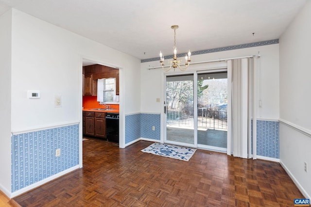 unfurnished dining area featuring sink, a notable chandelier, and dark parquet floors