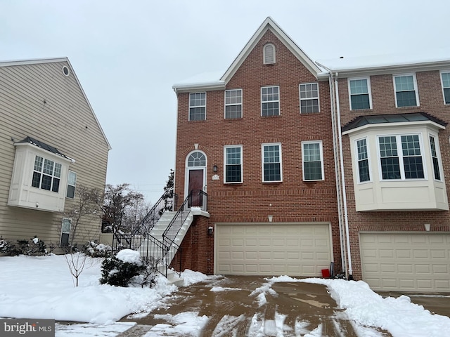 multi unit property featuring an attached garage and brick siding