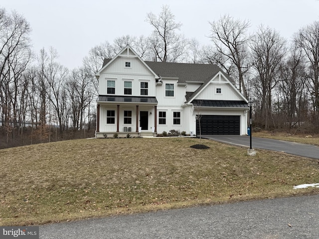 view of front of house featuring a porch, a garage, and a front lawn