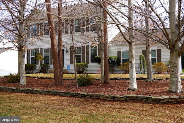 colonial inspired home featuring a front lawn