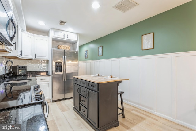 kitchen with stainless steel appliances, a center island, sink, and white cabinets