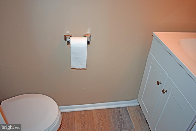 bathroom featuring vanity, hardwood / wood-style flooring, and toilet