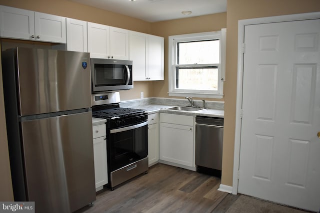 kitchen featuring dark wood-type flooring, appliances with stainless steel finishes, sink, and white cabinets