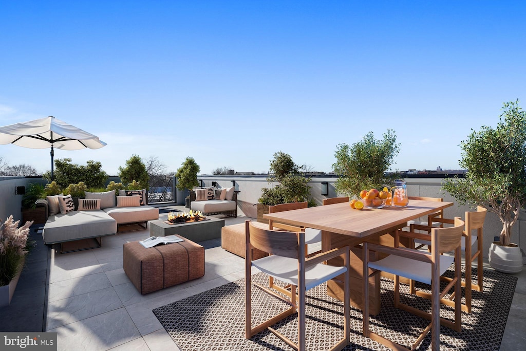 view of patio / terrace with outdoor dining space and an outdoor living space with a fire pit