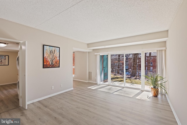 spare room with a textured ceiling and light wood-type flooring