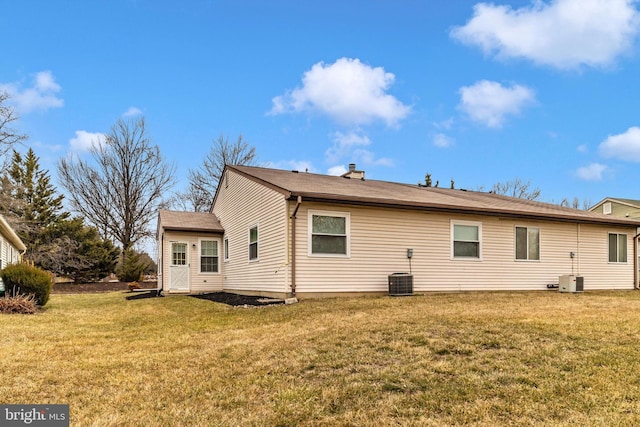 rear view of property with a yard and central air condition unit