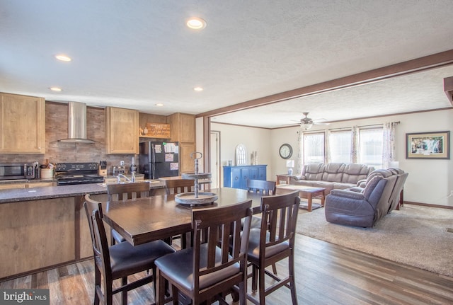 dining room featuring crown molding, dark wood-type flooring, ceiling fan, and a textured ceiling