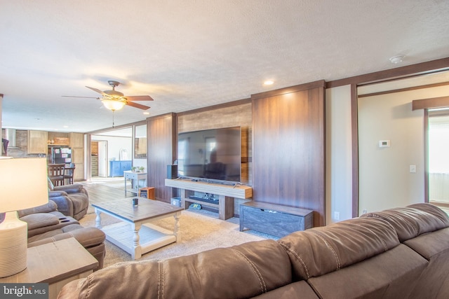 living room with ceiling fan and a textured ceiling