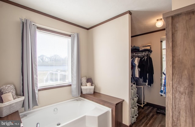 bathroom with a bathtub, crown molding, and wood-type flooring