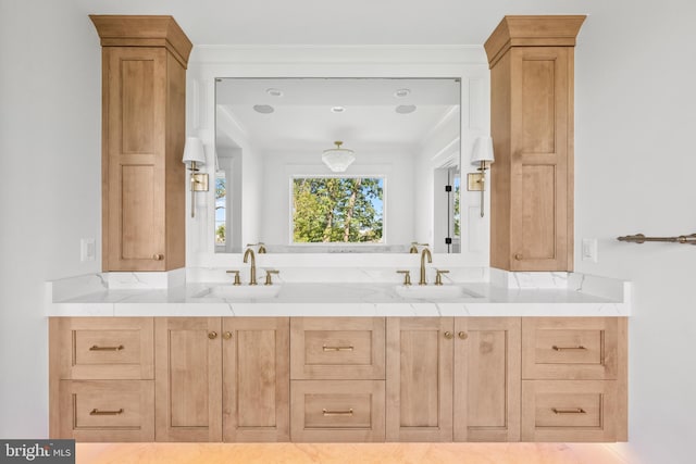 full bathroom featuring double vanity, ornamental molding, and a sink