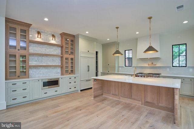 kitchen with glass insert cabinets, built in appliances, open shelves, light countertops, and visible vents