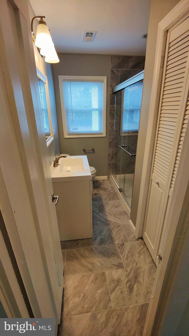 bathroom with vanity, an enclosed shower, and toilet