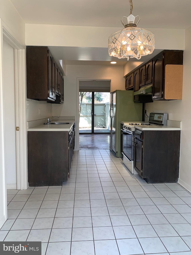 kitchen with light countertops, white gas range oven, dark brown cabinetry, and under cabinet range hood