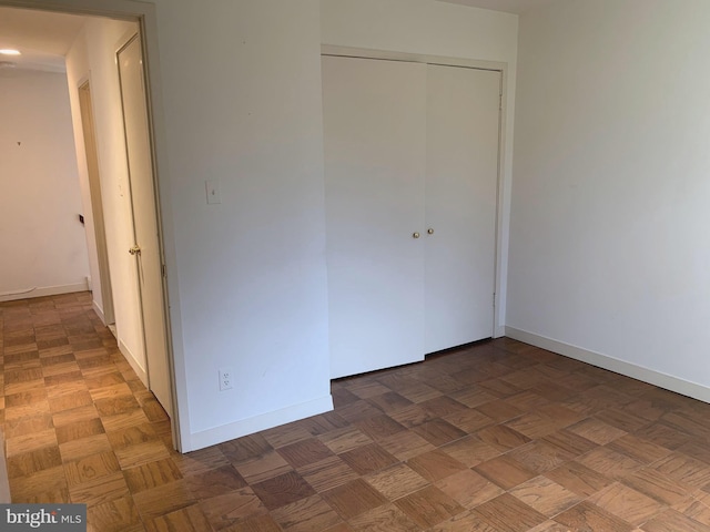 unfurnished bedroom with a closet and baseboards