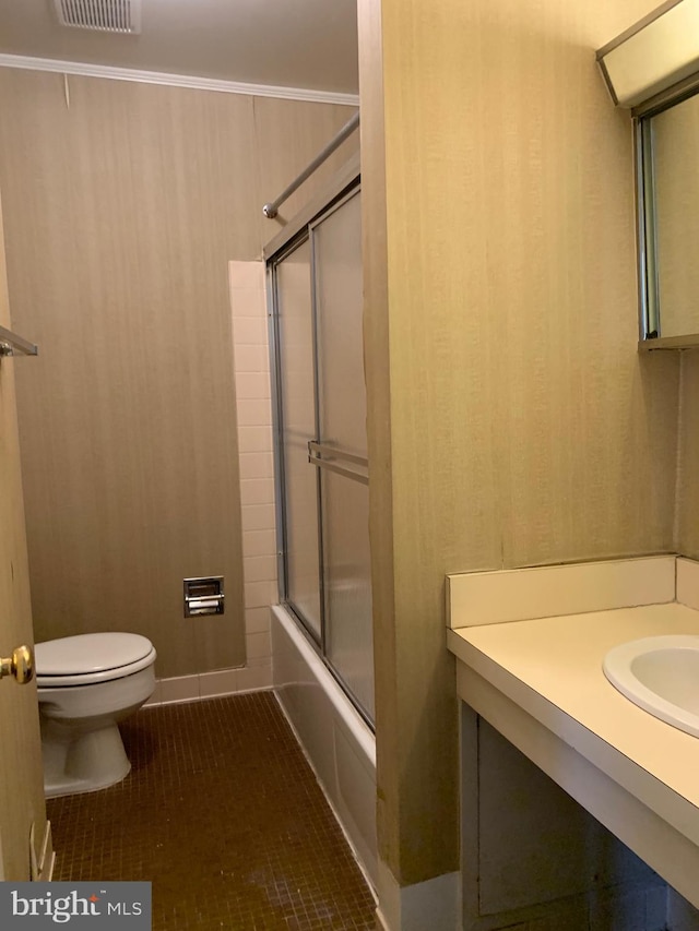 bathroom with toilet, enclosed tub / shower combo, tile patterned flooring, crown molding, and vanity