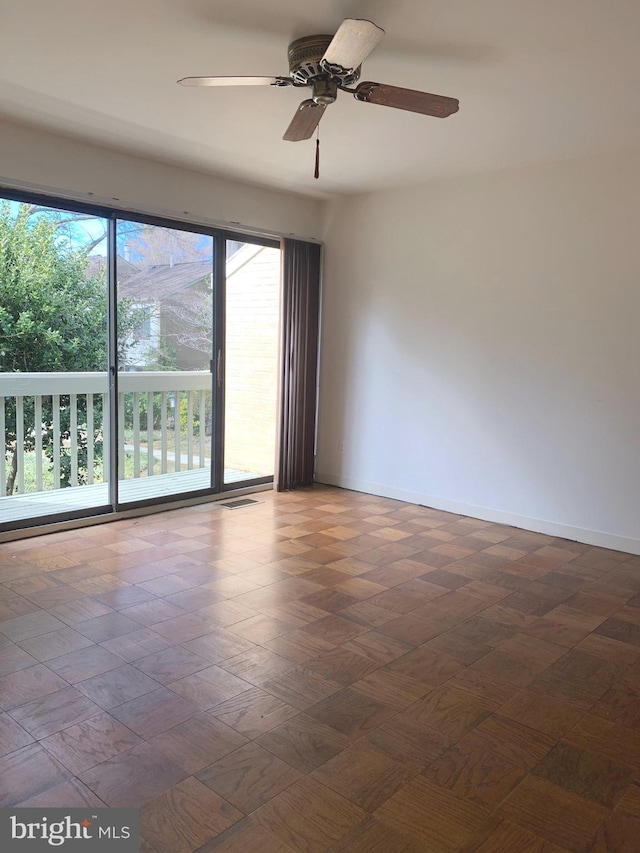 empty room featuring baseboards, visible vents, and ceiling fan