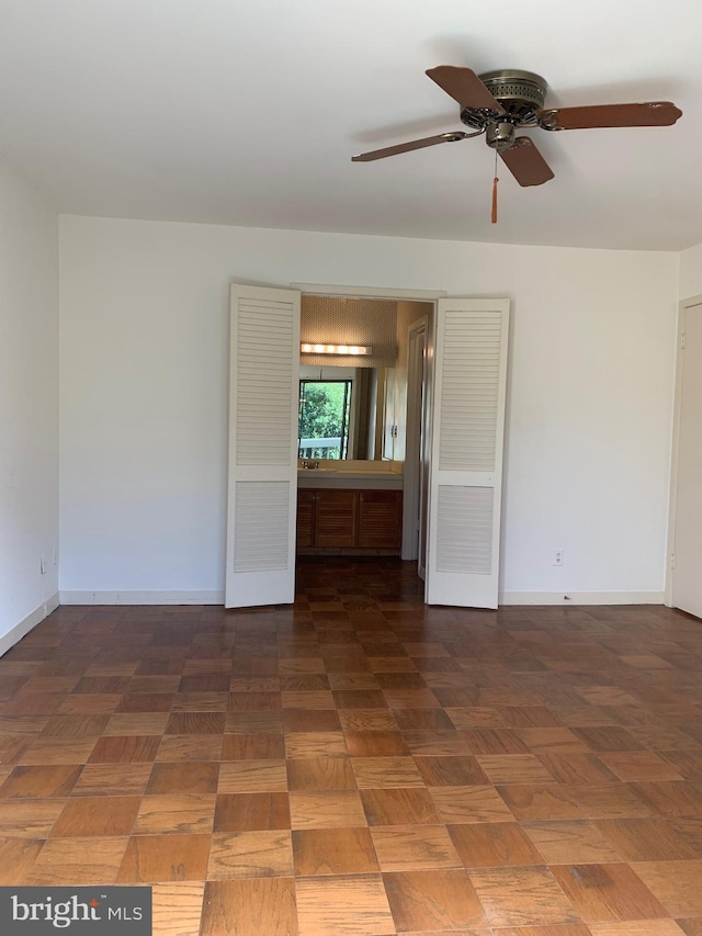 unfurnished room featuring ceiling fan and baseboards