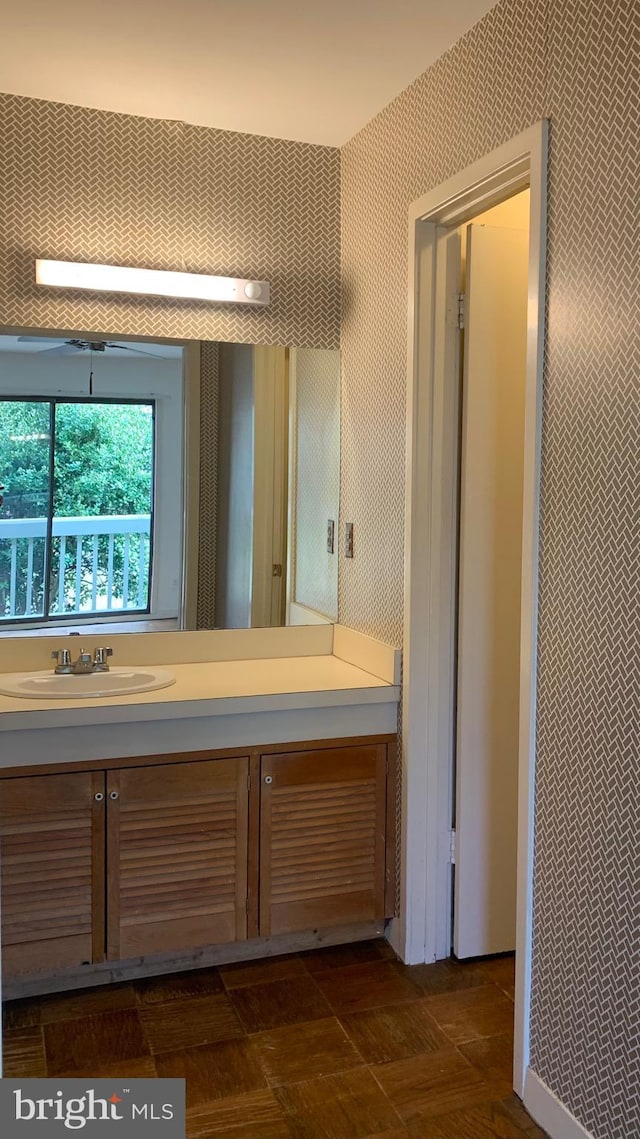 bathroom with vanity and wallpapered walls