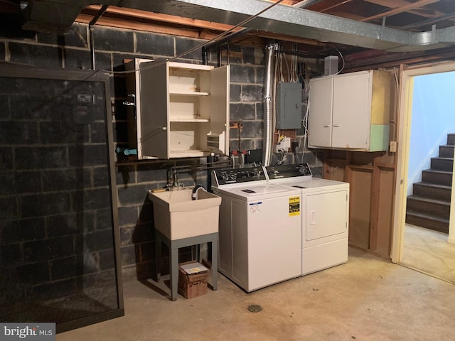 clothes washing area featuring electric panel, cabinet space, a sink, and washer and clothes dryer