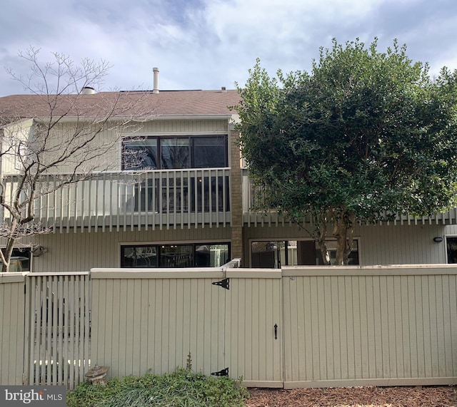 rear view of house featuring a fenced front yard