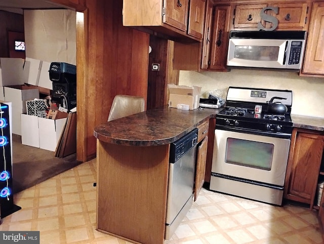 kitchen featuring stainless steel appliances and wooden walls