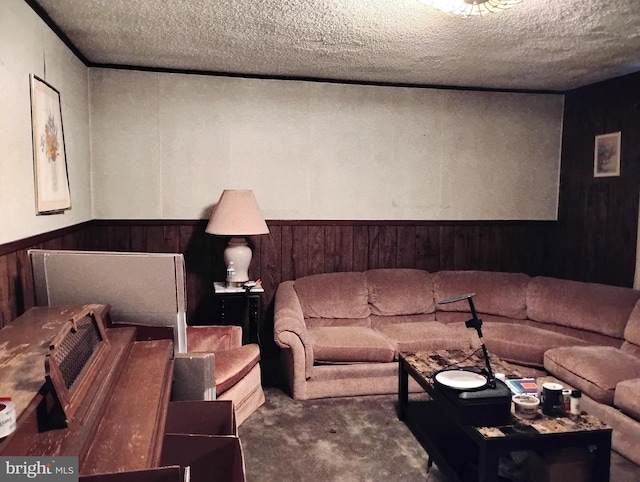 carpeted living room featuring wooden walls and a textured ceiling