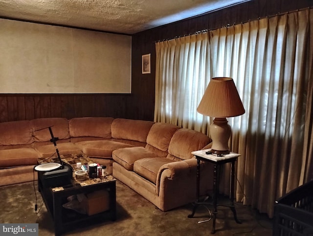 living room featuring wooden walls and a textured ceiling