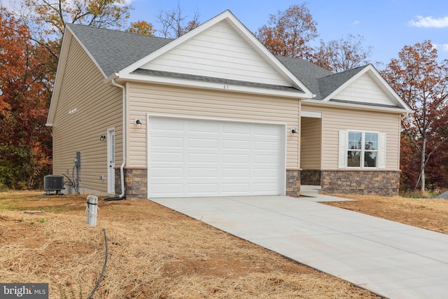 view of front of property with a garage and central AC