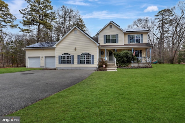 traditional-style house with driveway, roof mounted solar panels, a porch, and a front yard