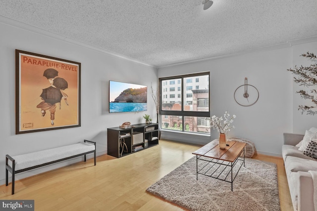 living area with a textured ceiling, crown molding, and wood finished floors